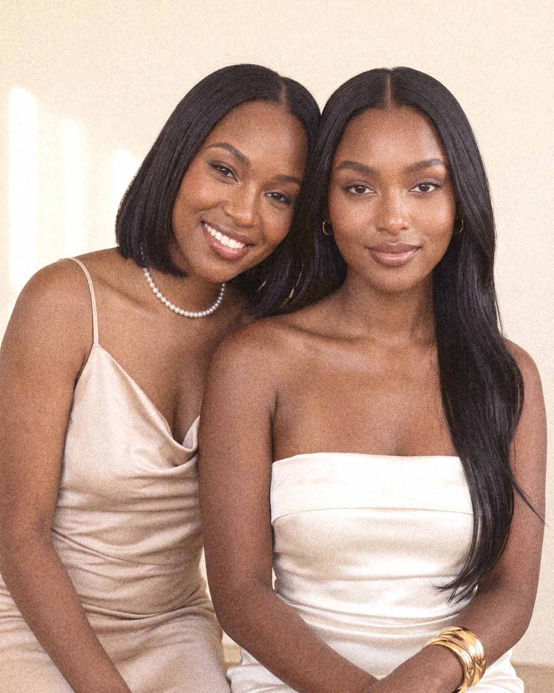 Two women sitting close together, smiling softly.